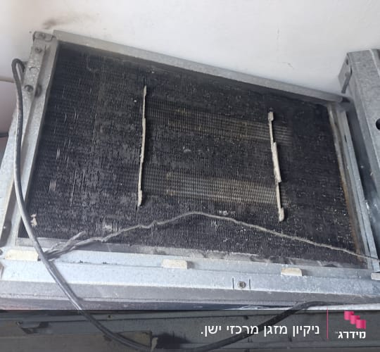 יחידת מזגן ישנה ומלוכלכת עם חוטים חשופים